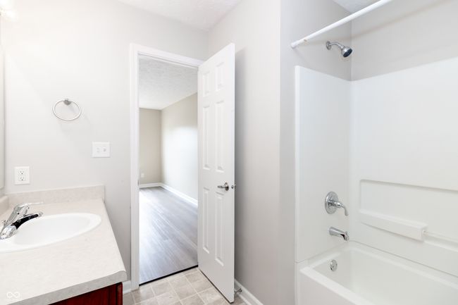 full bathroom featuring bathing tub / shower combination, vanity, and a textured ceiling | Image 21