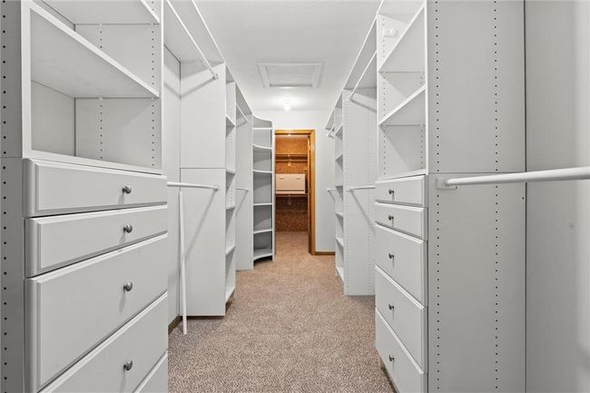 Walk in closet featuring light colored carpet | Image 30