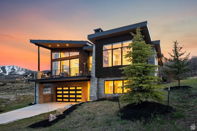 Contemporary home featuring a balcony, driveway, a front yard, a mountain view, and a garage | Image 11