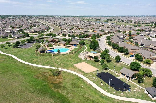 Birds eye view of community amenities including pool with clubhouse, sand volleyball court, and a basketball court, There's also a large covered playscape! | Image 33