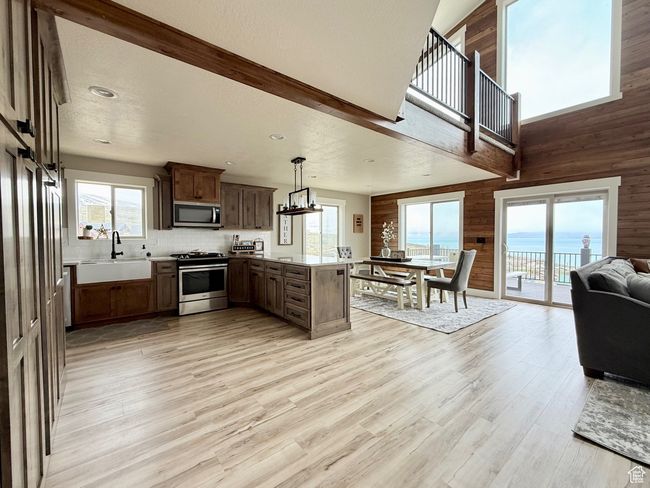 Kitchen with wooden walls, appliances with stainless steel finishes, a sink, a peninsula, and open floor plan | Image 15