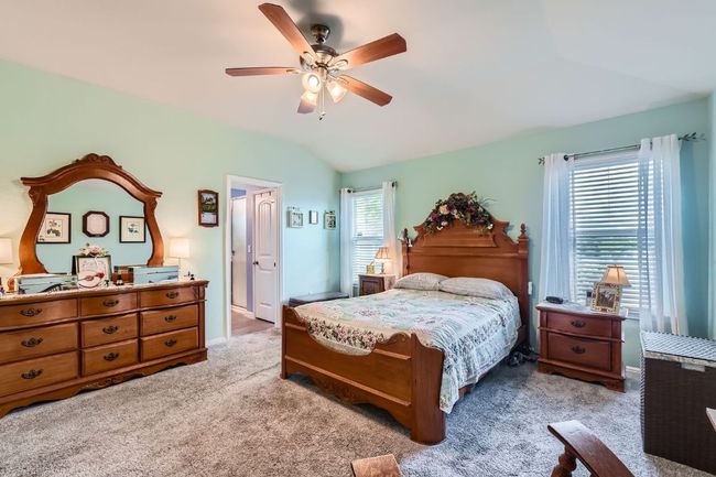 Bedroom with lofted ceiling, carpet flooring, baseboards, and a ceiling fan | Image 14