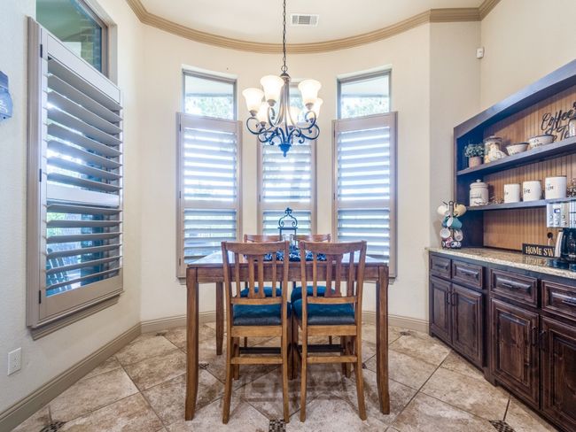 Dining space with a chandelier, healthy amount of natural light, crown molding, and light tile patterned floors | Image 12