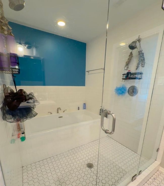 Primary bath has a wet room with two person soaking tub and dual shower heads. | Image 10
