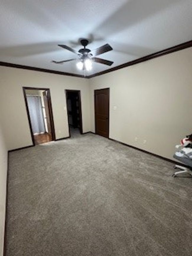 Unfurnished bedroom featuring ornamental molding, light colored carpet, and a ceiling fan | Image 10
