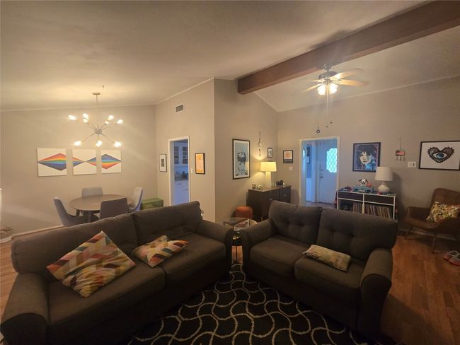 Living area with wood finished floors, a chandelier, and a ceiling fan | Image 16