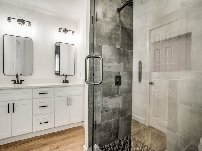 Full bathroom with a stall shower, double vanity, and wood finished floors | Image 9