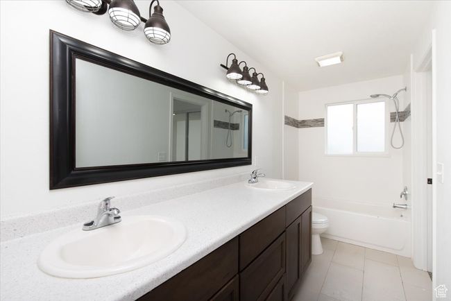 Bathroom featuring double vanity, a sink, shower / bath combination, and toilet | Image 21