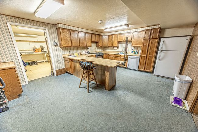 Kitchen with carpet floors, a textured ceiling, kitchen peninsula, and stainless steel appliances | Image 46