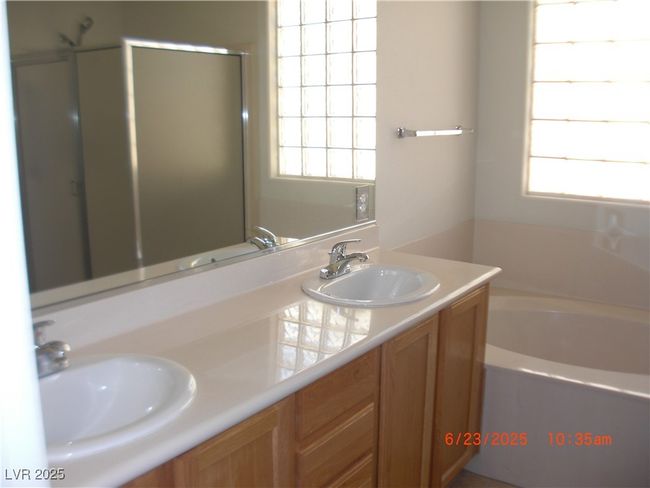 Full bathroom featuring double vanity, plenty of natural light, a garden tub, and a stall shower | Image 9
