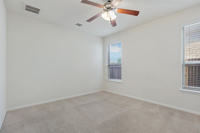Empty room featuring baseboards, a ceiling fan, visible vents, and carpet | Image 21