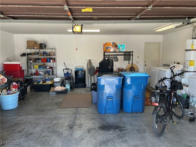 Garage featuring washer and dryer, a garage door opener, and secured water heater | Image 41