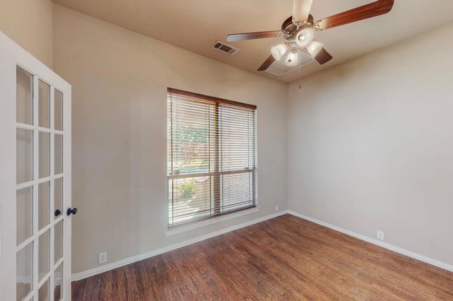 Empty room with wood finished floors, ceiling fan, and french doors | Image 8