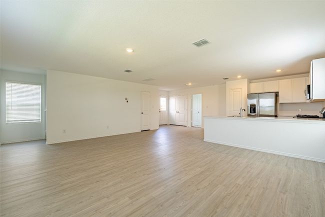 Unfurnished living room with a sink, recessed lighting, light wood-style floors, and baseboards | Image 4