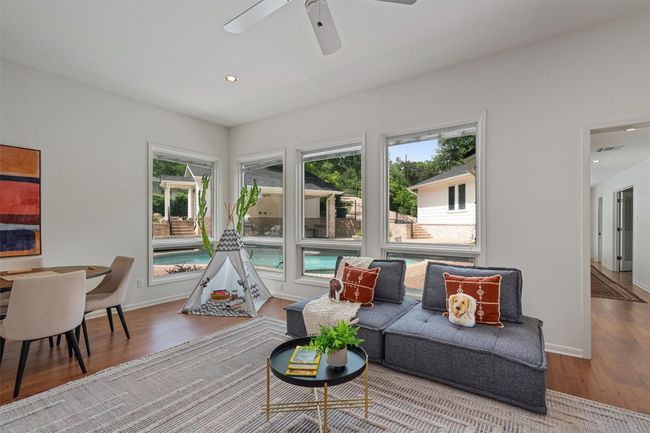 Living area with wall of windows provides a view of the pool and outdoor living area | Image 24