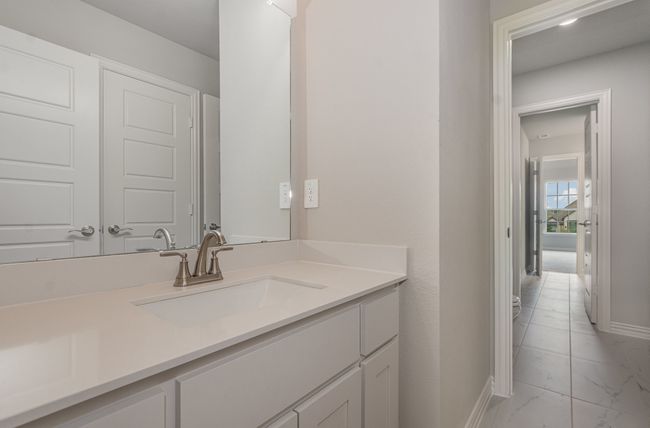 Bathroom with marble look tiles, vanity, and baseboards | Image 31