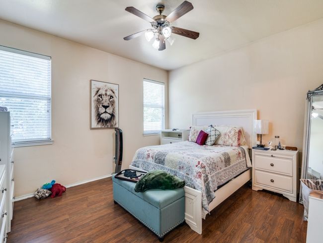 Bedroom with a ceiling fan, baseboards, and dark wood finished floors | Image 18