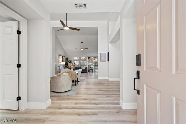 Inside you'll discover soaring majestic ceilings, an open-concept floor plan, sleek pocket windows, & warm natural light. The upgraded interior features luxury flooring, fresh designer paint, & new baseboards. Relax by the linear fireplace or entertain in the formal dining area. | Image 9