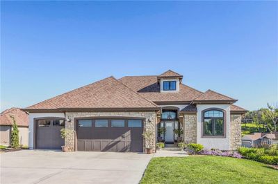 View of front facade with a garage and a front lawn | Image 1