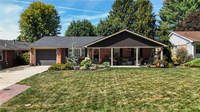 View of front facade with a front yard and a garage | Image 1