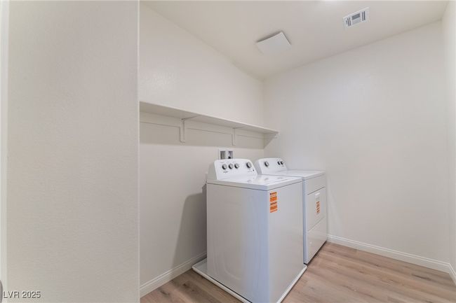 Laundry area with separate washer and dryer and light wood-style floors | Image 34