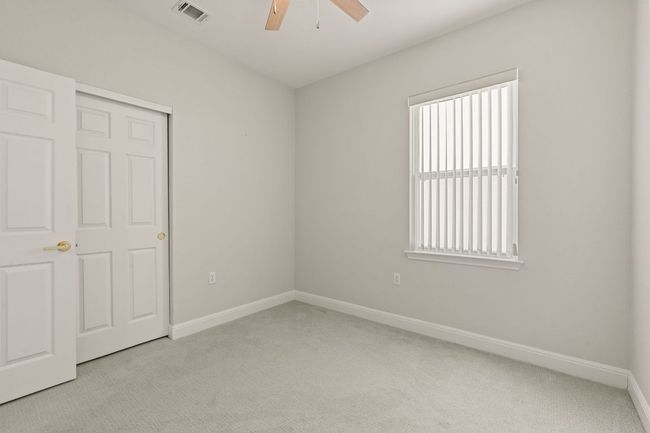 Unfurnished bedroom with baseboards, visible vents, a ceiling fan, light carpet, and a closet | Image 29