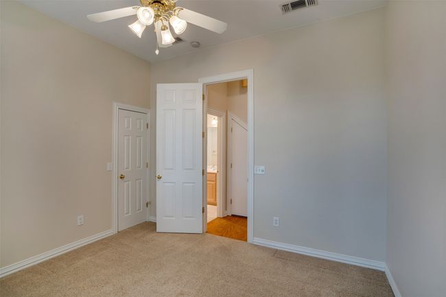 Unfurnished bedroom with light carpet, baseboards, and a ceiling fan | Image 24