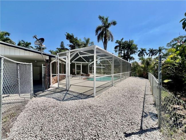 Rear view of property with an outdoor pool, a patio area, a lanai, and a fenced backyard | Image 28