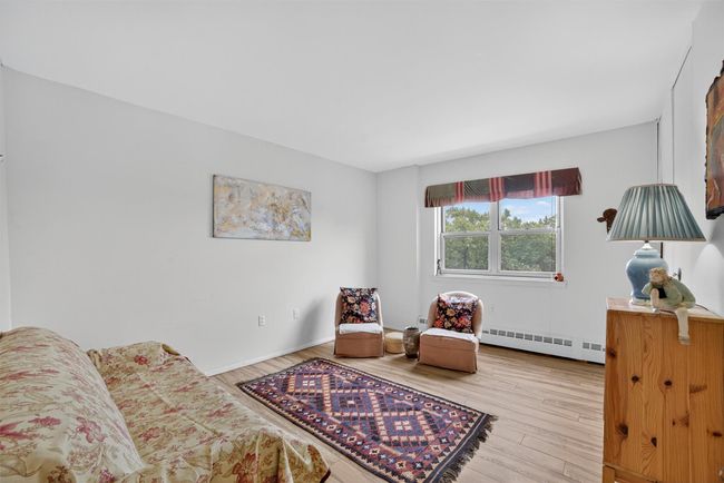 Sitting room with a baseboard heating unit and wood finished floors | Image 31