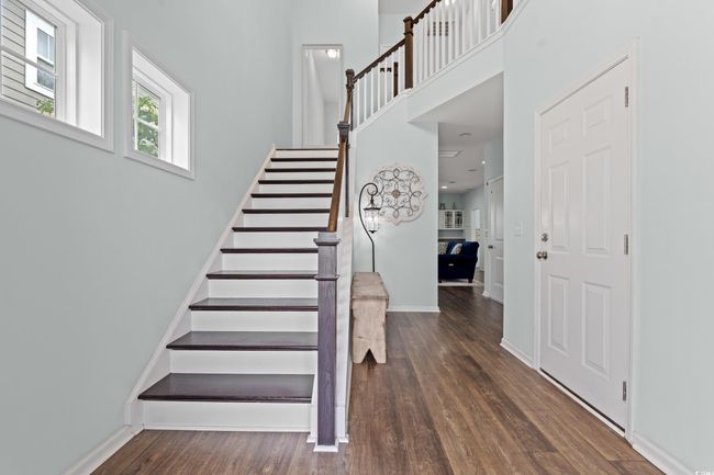 Stairs featuring wood finished floors and a high ceiling. | Image 4