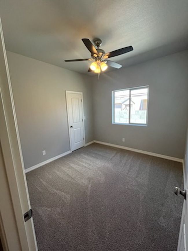Empty room featuring baseboards, dark colored carpet, and ceiling fan | Image 29