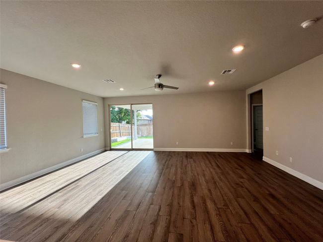 Spare room with ceiling fan, dark wood finished floors, a smoke detector, and recessed lighting | Image 4