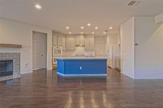 Kitchen featuring white appliances, tasteful backsplash, dark wood-type flooring, light countertops, and recessed lighting | Image 11