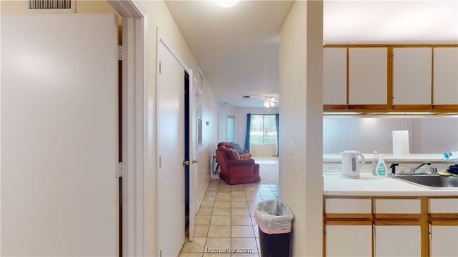 Kitchen featuring white cabinets, sink, ceiling fan, and light tile patterned floors | Image 6