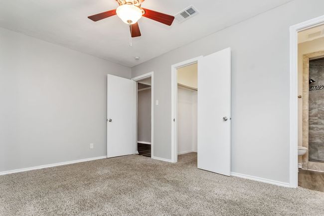 Unfurnished bedroom with carpet floors, ensuite bathroom, a closet, and ceiling fan | Image 13