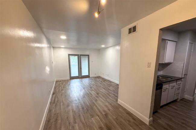 Empty room with dark wood-style flooring and recessed lighting | Image 17