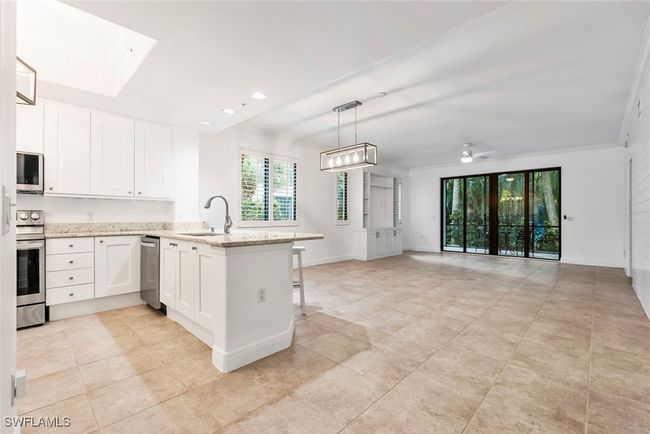 Kitchen featuring kitchen peninsula, sink, white cabinetry, appliances with stainless steel finishes, and ceiling fan | Image 29