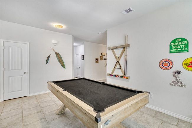 Recreation room with pool table and light tile patterned floors | Image 8