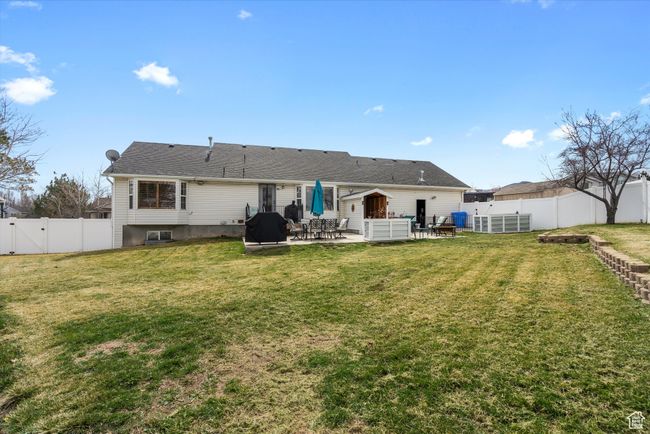 Rear view of house featuring a patio, a gate, a FULLYfenced backyard | Image 34