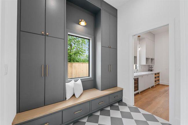 The mudroom blends function with elevated design, featuring custom cabinetry, designer tile flooring, and a built-in white oak bench for seamless storage and style. Thoughtfully placed just off the entry, it’s a beautifully practical landing space for daily life. | Image 13