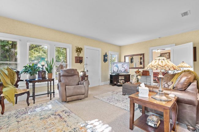 Carpeted living area featuring plenty of natural light and baseboards | Image 7