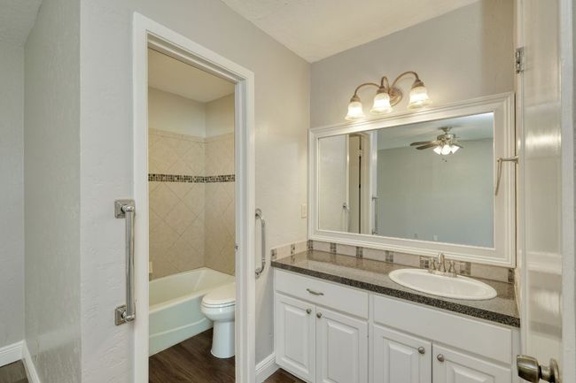 Full bath featuring vanity, ceiling fan, wood finished floors, and tub / shower combination | Image 8