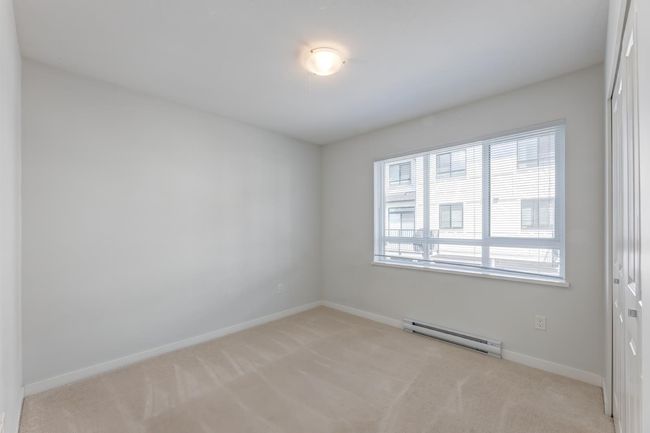 Spare room with baseboard heating and light carpet | Image 25