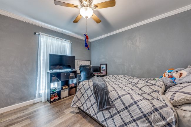 Bedroom featuring wood finished floors, ornamental molding, and a ceiling fan | Image 18
