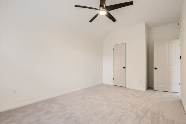Unfurnished bedroom with light carpet, baseboards, lofted ceiling, and ceiling fan | Image 32