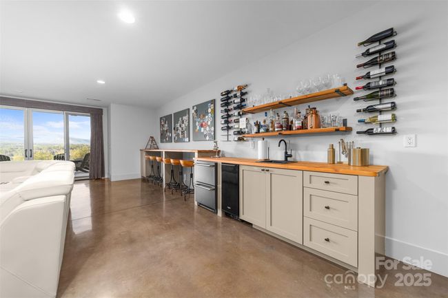 Lower level game room includes big mountain views with entertainment wet-bar and walk out to the patio and pool area. | Image 25