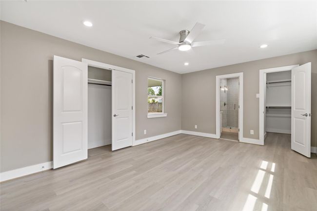 Primary bedroom with view of bathroom, 2 closets, and windows (even in bathroom) overlooking the back yard. | Image 7