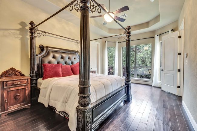 Owners bedroom featuring dark hardwood flooring and a raised tray ceiling | Image 30