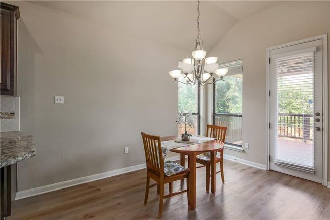 Dining room with a chandelier, wood finished floors, and vaulted ceiling | Image 8