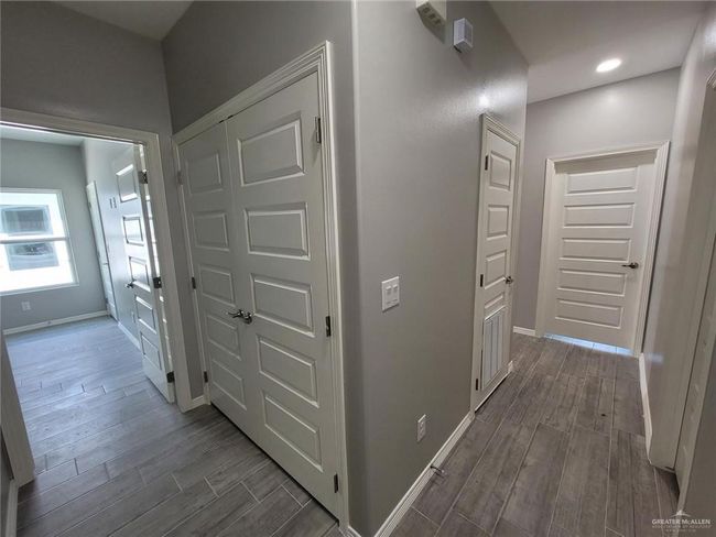 Hall featuring baseboards and dark wood-style flooring | Image 4